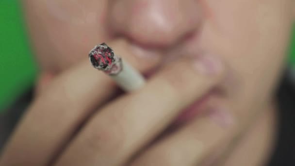 Sigaretta in bocca a un fumatore. Primo piano. Chiave cromatica. Sfondo verde . — Video Stock