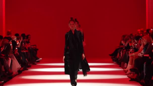 ファッションショーモデルのグループは、キャットウォーク上を歩く。スローモーション — ストック動画