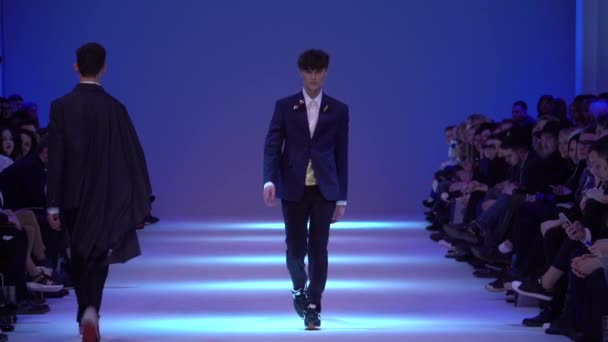 Чоловіча модель ходить по тротуару під час показу моди. Повільний рух. — стокове відео