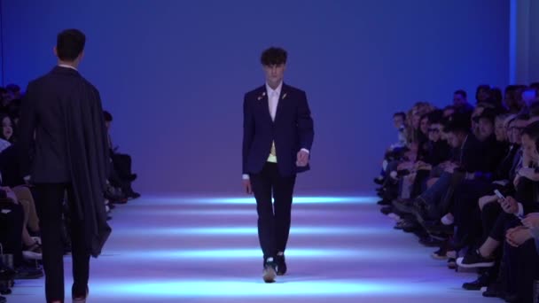 Mannelijk model loopt op de catwalk tijdens een modeshow. Langzame beweging. — Stockvideo