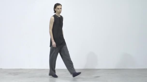 Manlig modell går på catwalken under en modevisning. Långsamma rörelser. — Stockvideo