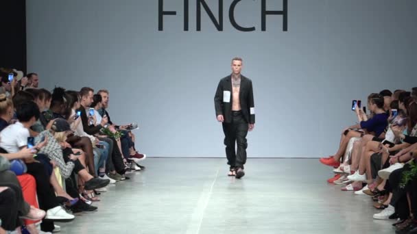 Mężczyzna-modelka spaceruje po wybiegu podczas pokazu mody. Zwolniony ruch. — Wideo stockowe
