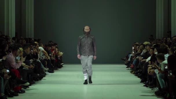 Manlig modell går på catwalken under en modevisning. Långsamma rörelser. — Stockvideo