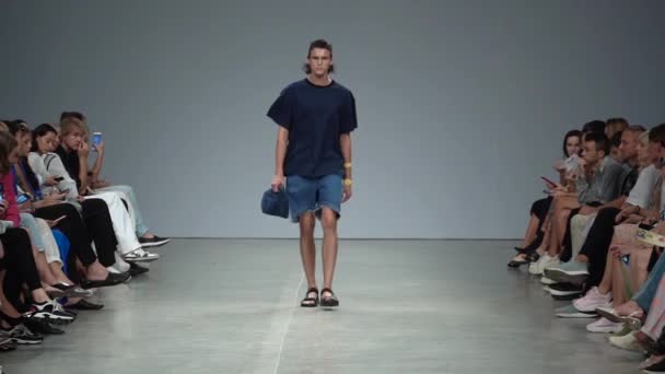 Mannelijk model loopt op de catwalk tijdens een modeshow. Langzame beweging. — Stockvideo