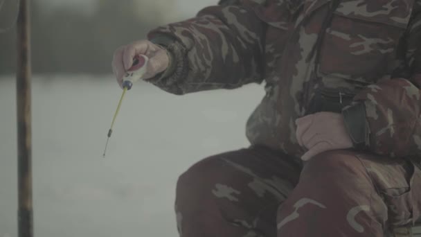 Pêche d'hiver. Homme pêcheur capture du poisson en hiver — Video