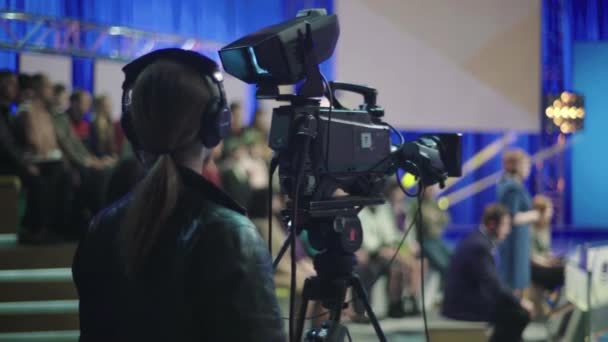 Cameraman με κάμερα στο στούντιο τηλεόρασης κατά τη διάρκεια της τηλεοπτικής εγγραφής — Αρχείο Βίντεο