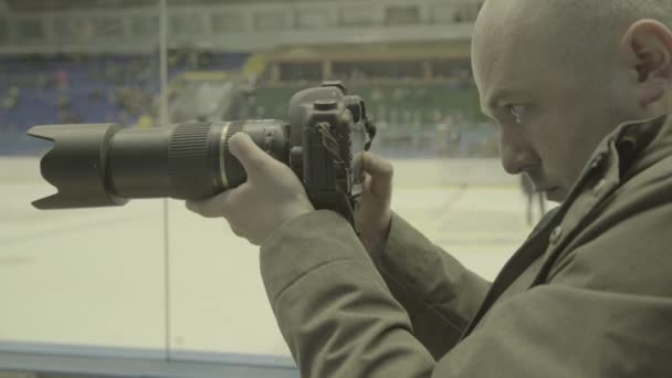 Cameraman con una macchina fotografica a una partita di hockey . — Video Stock