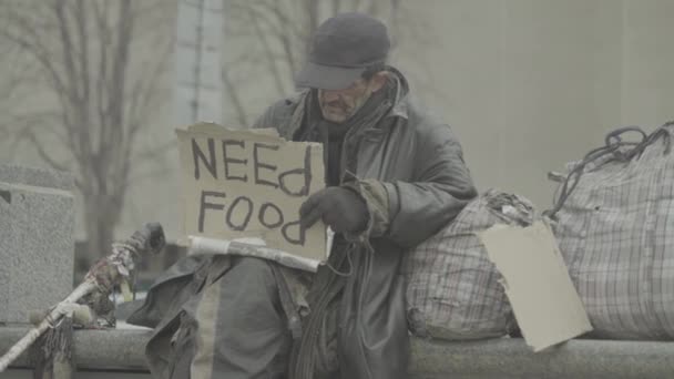 Inskriptionen "Behöver mat" av en fattig hemlös slampa. Kiev. Ukraina — Stockvideo