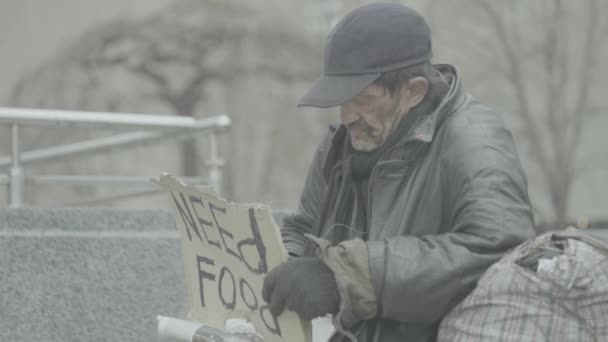 A inscrição "Precisa de comida" por um vagabundo pobre sem-teto. Kiev. Ucrânia — Vídeo de Stock