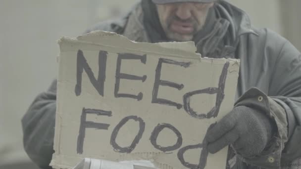 Inskriptionen "Behöver mat" av en fattig hemlös slampa. Kiev. Ukraina — Stockvideo