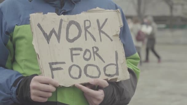 Die Aufschrift "Arbeit für Nahrung" des armen Obdachlosen. kyiv. Ukraine — Stockvideo