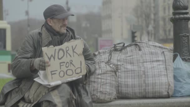 可怜的无家可归的流浪汉的题词"为食物而工作" 。 Kyiv 。 乌克兰 — 图库视频影像