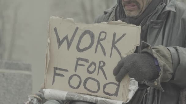 Die Aufschrift "Arbeit für Nahrung" des armen Obdachlosen. kyiv. Ukraine — Stockvideo