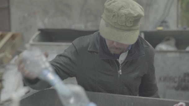 Ein Bettler, der obdachlos ist, sucht in einem Mülleimer nach Essen. Kiew. Ukraine — Stockvideo