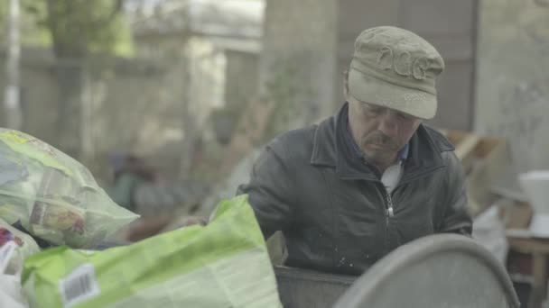 一个无家可归的乞丐流浪汉正在垃圾桶里寻找食物。Kyiv 。乌克兰 — 图库视频影像
