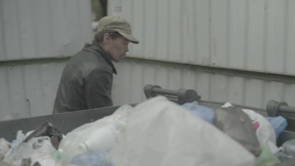 Bezdomny żebrak szuka jedzenia w koszu na śmieci. Kijów. Ukraina — Wideo stockowe
