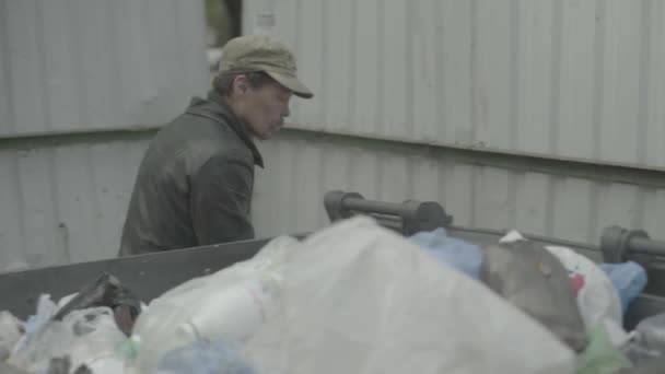 Un barbone barbone mendicante sta cercando del cibo in un bidone della spazzatura. Kiev. Ucraina — Video Stock