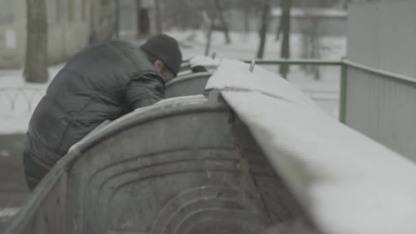 Žebrák bezdomovec tulák hledá jídlo v popelnici. Kyjev. Ukrajina — Stock video