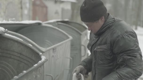 A beggar homeless man tramp is looking for food in a trash can. Kyiv. Ukraine — Stock Video