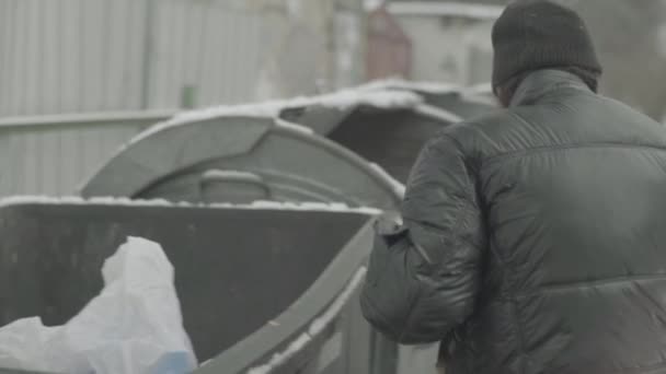 Бездомный бродяга ищет еду в мусорном баке. Киев. Украина — стоковое видео