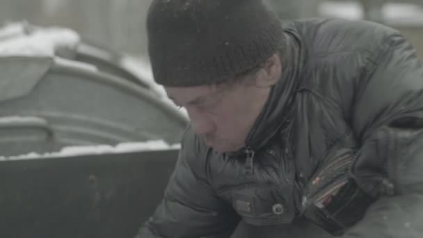 A beggar homeless man tramp is looking for food in a trash can. Kyiv. Ukraine — Stock Video