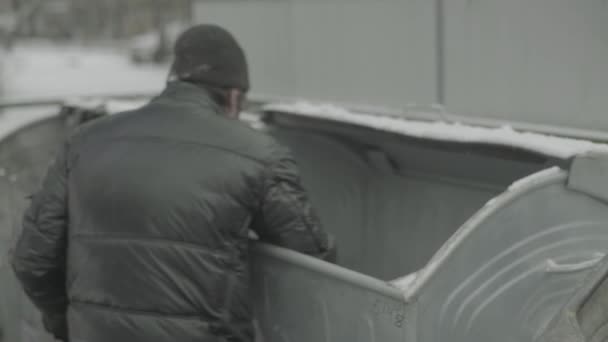 Dilenci evsiz bir serseri çöp tenekesinde yiyecek arıyor. Kyiv. Ukrayna — Stok video