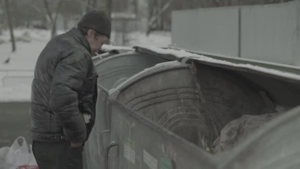 En hemlös tiggare letar efter mat i en soptunna. Kiev. Ukraina — Stockvideo