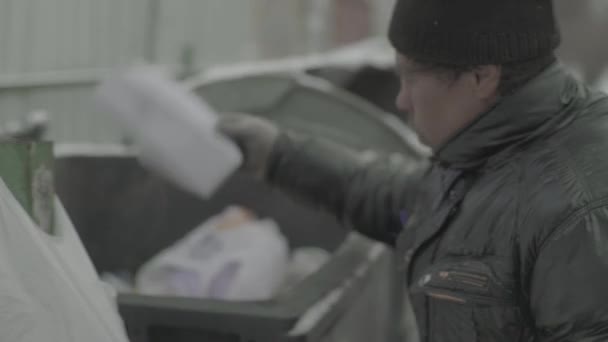 A beggar homeless man tramp is looking for food in a trash can. Kyiv. Ukraine — Stock Video