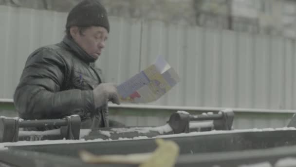 Un vagabundo mendigo sin hogar está buscando comida en un cubo de basura. Kiev. Ucrania — Vídeos de Stock