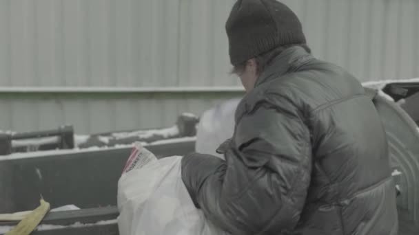 A beggar homeless man tramp is looking for food in a trash can. Kyiv. Ukraine — Stock Video