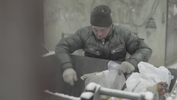 Ein Bettler, der obdachlos ist, sucht in einem Mülleimer nach Essen. Kiew. Ukraine — Stockvideo