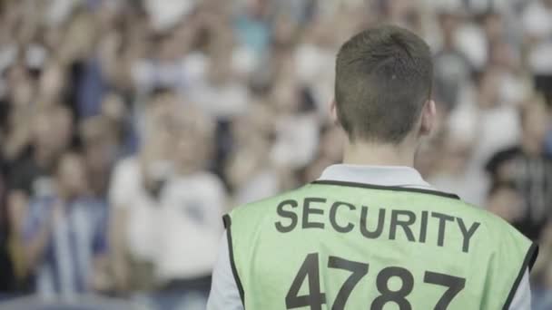 Male security guard in a stadium during a football soccer match. — Stock Video