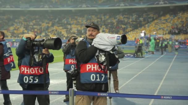 Egy fotós fotós egy kamerával a stadionban egy focimeccs alatt. — Stock videók