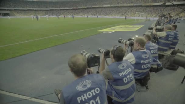 Ein Fotograf mit einer Kamera in einem Stadion während eines Fußballspiels. — Stockvideo