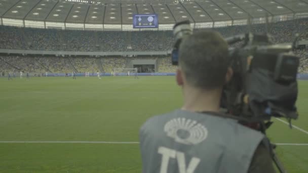 Operatőr egy kamerával a stadionban egy focimeccs alatt. TV — Stock videók