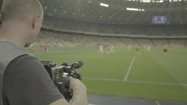 Caméraman avec une caméra dans le stade pendant un match de football. Télévision — Video