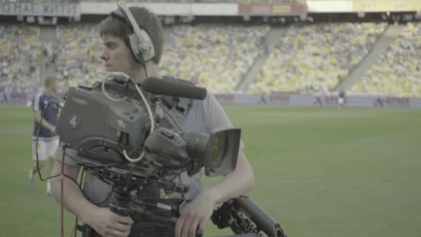 Caméraman avec une caméra dans le stade pendant un match de football. Télévision — Video