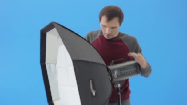 Człowiek fotograf przygotowuje sprzęt przed sesją zdjęciową w studio — Wideo stockowe