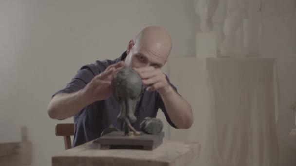 Man mannelijke beeldhouwer werkt aan de creatie van beeldhouwkunst. Kiev. Oekraïne. — Stockvideo