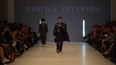 Moda gösterisi. Erkek manken podyumda yürüyor..