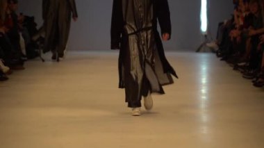 Moda gösterisi. Erkek manken podyumda yürüyor..