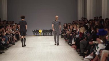 Moda gösterisi. Erkek manken podyumda yürüyor..