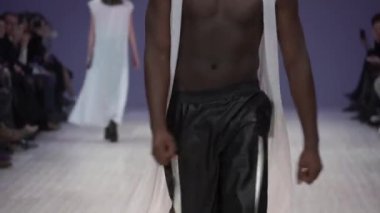 Moda gösterisi. Erkek manken podyumda yürüyor..