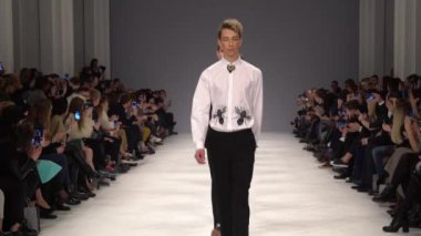Moda gösterisi. Erkek manken podyumda yürüyor..