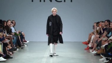 Moda gösterisi. Erkek manken podyumda yürüyor..