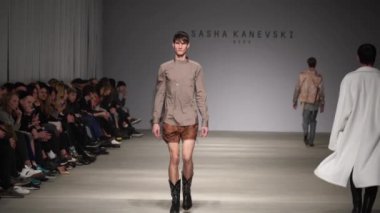 Moda gösterisi. Erkek manken podyumda yürüyor..