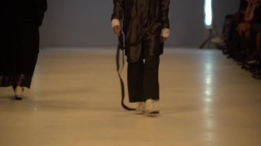 Moda gösterisi. Erkek manken podyumda yürüyor..