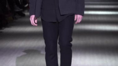 Moda gösterisi. Erkek manken podyumda yürüyor..