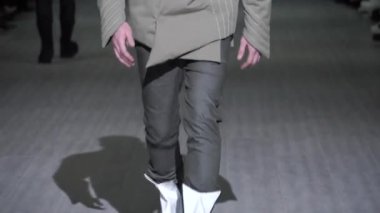 Moda gösterisi. Erkek manken podyumda yürüyor..