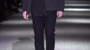 Moda gösterisi. Erkek manken podyumda yürüyor..